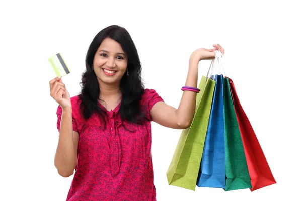 Mujer joven sosteniendo bolsas de compras y tarjeta de crédito —  Fotos de Stock