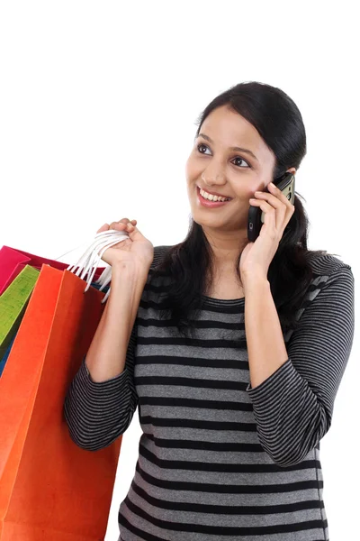 Junge Frau mit Einkaufstüten und Handy im Gespräch — Stockfoto