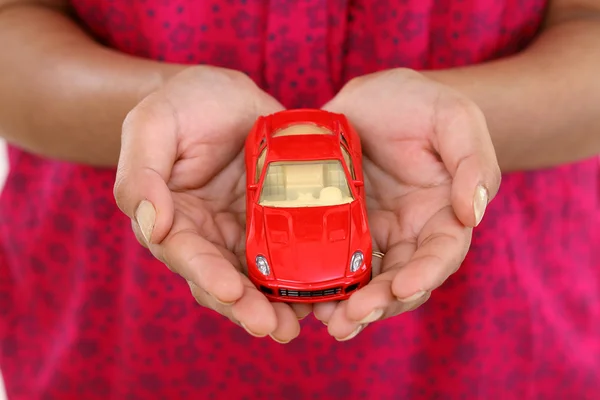 Carro de brinquedo vermelho nas mãos — Fotografia de Stock