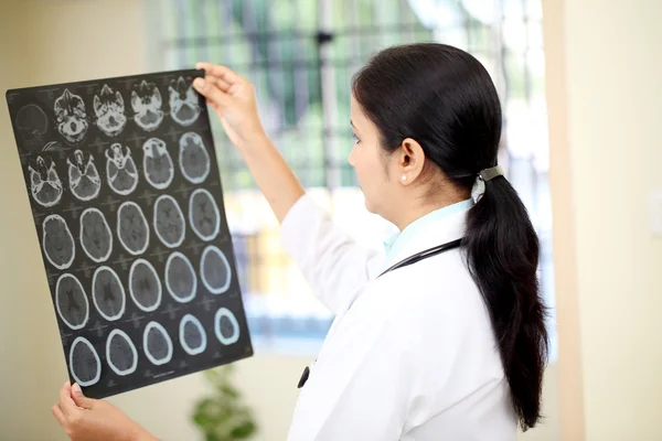 Kadın doktor beyin bilgisayarlı tomografi inceleyerek inceden inceye gözden geçirmek