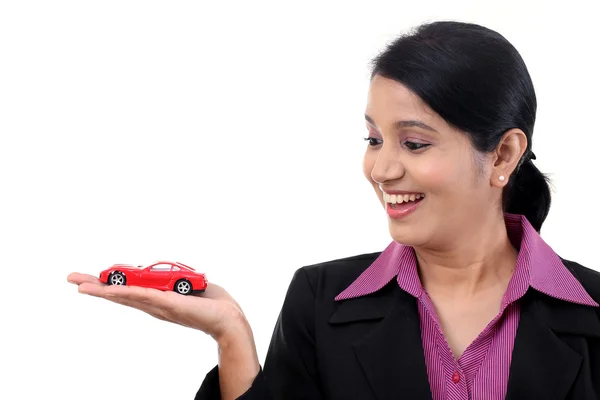 Happy young business woman holding toy car — Stock Photo, Image