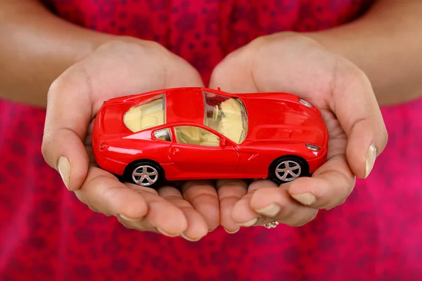 Carro de brinquedo vermelho na mão contra fundo branco — Fotografia de Stock