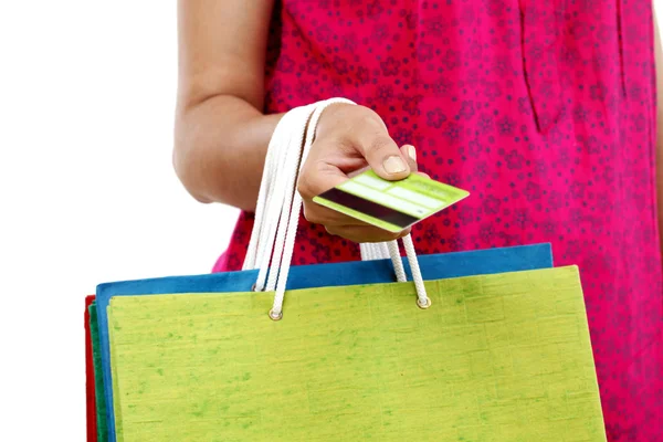 Mão feminina segurando sacos de compras e cartão de crédito no backg branco — Fotografia de Stock