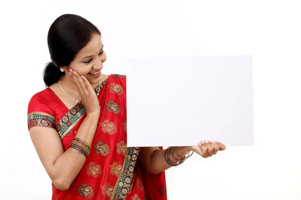 Vrolijke traditionele Indiase vrouw houdt van een leeg reclamebord — Stockfoto