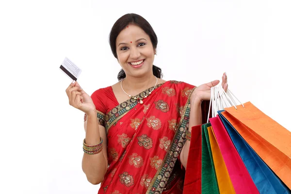 Junge lächelnde traditionelle Frau mit Einkaufstaschen und Kreditkarte — Stockfoto