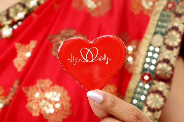 Παραδοσιακή ινδική γυναίκα που κρατά κόκκινου σχήμα καρδιάς — Φωτογραφία Αρχείου