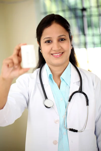 Female doctor holding up a bottle of tablets