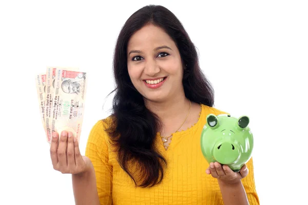 Jovem mulher economiza dinheiro no porquinho banco — Fotografia de Stock
