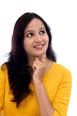 Beyaz arka plan üzerinde düşünerek mutlu genç kadın