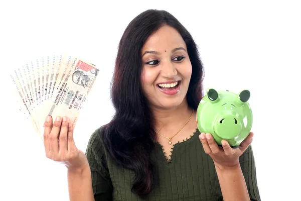 Junge Frau spart Geld in Sparschwein — Stockfoto