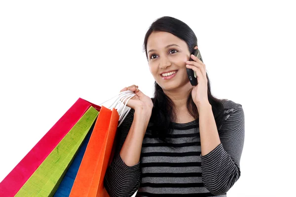 Jonge vrouw met winkelen zakken en praten op mobiele telefoon — Stockfoto
