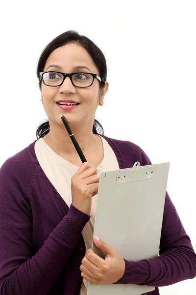 Jovem mulher pensando ao tomar notas contra fundo branco — Fotografia de Stock
