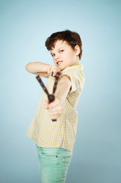 Смешной мальчик с деревянной рогаткой
