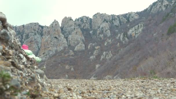 Niña en un sendero de montaña, la niña en las montañas — Vídeos de Stock