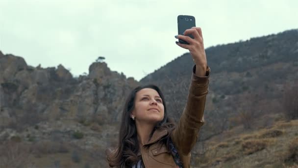 Menina bonita faz selfie com seu telefone inteligente. Imagem tonificada — Vídeo de Stock