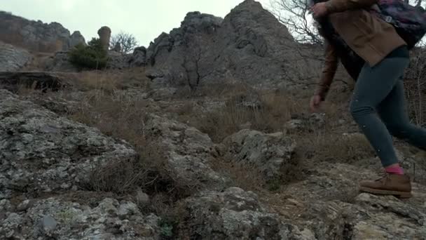 Randonneuse jeune femme avec sac à dos marchant dans les montagnes par temps pluvieux — Video