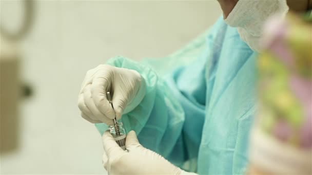 Surgery, the assistant pulls out the flask of artificial crystalline lens — Stock Video