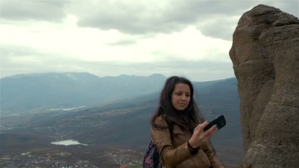 Mulher jovem caminhante tirar foto com telefone inteligente no pico da montanha — Vídeo de Stock