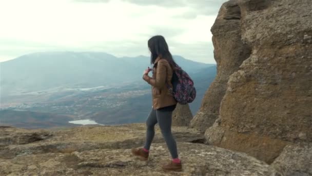 Young lady hiker with backpack, with the top of the mountain — Stock Video