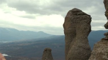 Genç bayan yürüyüşçü dağ zirvesinde akıllı telefonuyla fotoğraf çekiyor.