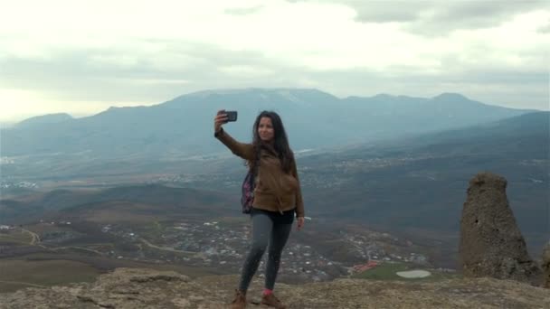 Mujer joven excursionista tomando fotos con teléfono inteligente en el pico de la montaña — Vídeos de Stock