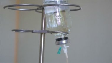 sıvı ilaç şişe kısmen görünür metin katarı ile... Aktif madde... Sodyum Klorür... Bir damlalık ayağı ameliyat sırasında su