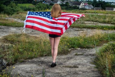 Şortlu kız, elinde ABD bayrağıyla parka geri dönüyor..