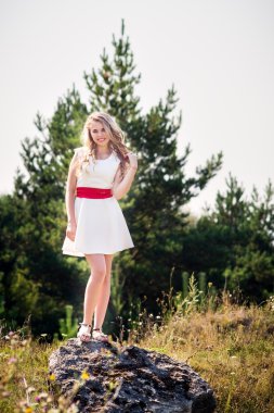 Beyaz elbiseli, gülümseyen kız.