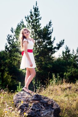 Beyaz elbiseli, gülümseyen kız.