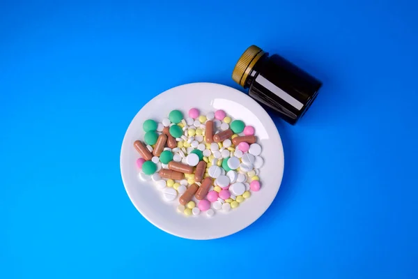 Tabletki Talerzu Czarna Butelka Niebieskim Tle Osoba Spożywająca Tabletki — Zdjęcie stockowe