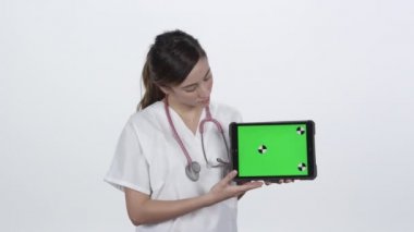 Sonuçları yeşil ekranlı tablet üzerinde gösteren doktor.