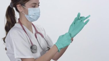 Hemşire lastik eldiveni takıp işaret parmağını havaya kaldırarak rahatsız edici bir sınav yapıyor..