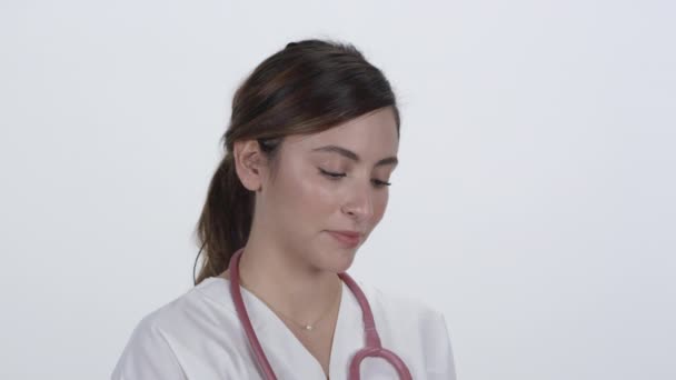 白地を背景にカメラを見上げ笑顔を見せる医療関係者 — ストック動画