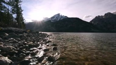Wyoming 'de gün batımında Grand Tetons' da Jenny Gölü 'nün sularında yüzüyorlar..