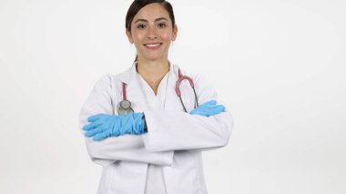 Kadın doktor kollarını kıvırıp gülümserken beyaz arka planda onlara doğru ilerliyor..