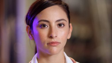 Kadın doktor kollarını kıvırıp gülümserken beyaz arka planda onlara doğru ilerliyor..