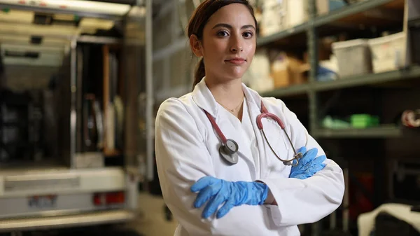 Kadın doktor kollarını kıvırıp gülümserken beyaz arka planda onlara doğru ilerliyor..