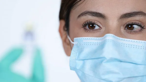 Kadın doktor kollarını kıvırıp gülümserken beyaz arka planda onlara doğru ilerliyor..