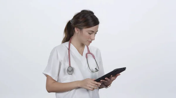 Kadın doktor kollarını kıvırıp gülümserken beyaz arka planda onlara doğru ilerliyor..