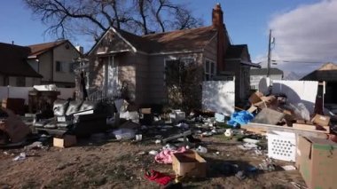 Eski bir evin bahçesindeki çöplerin arasında yürürken evin etrafını bir yığın çöp sarmış..