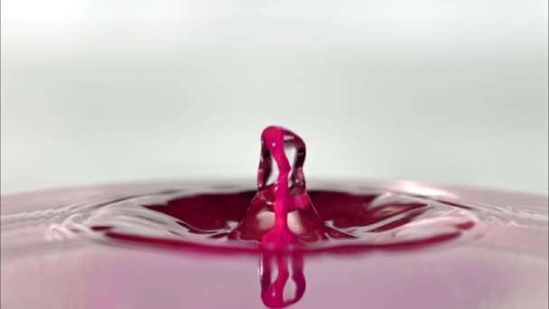 Πιτσιλιές Νερού Καθώς Ροζ Σταγονόμετρο Πέφτει Στην Επιφάνεια Και Αναπηδά — Αρχείο Βίντεο
