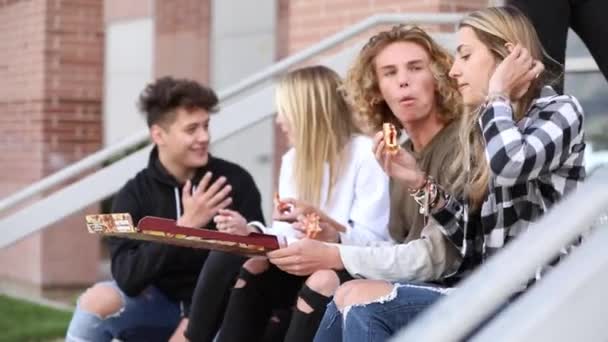 Grupa Nastolatków Spędza Czas Jedząc Pizzę Siedząc Schodach Liceum — Wideo stockowe