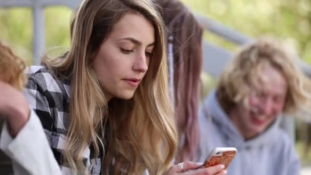 Chica Adolescente Mirando Través Teléfono Sentado Los Pasos Mientras Otros — Vídeo de stock