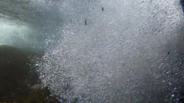 小川の現在のサージから表面に上昇する泡として小さな滝の下の水中ビュー — ストック動画