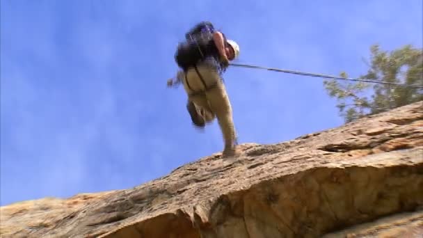 Mountain Climber Rappelling Down A Cliff Stock Video