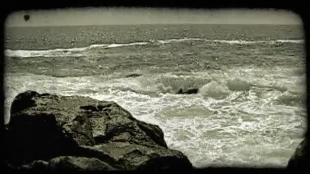 Des vagues s'écrasent contre des rochers. Vintage stylisé clip vidéo . — Video