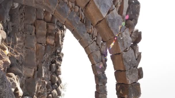 Каменные арки среди обломков под открытым небом — стоковое видео