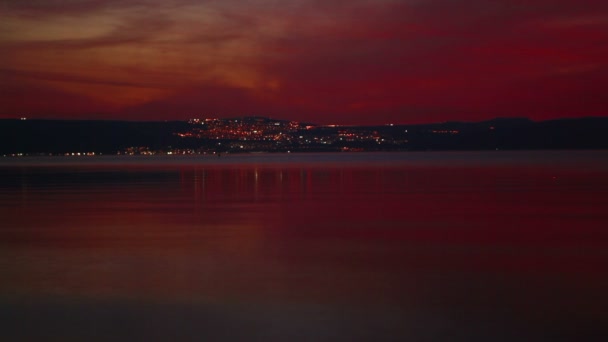 วิดีโอสต็อกของไฟเมืองที่ห่างไกลในเวลากลางคืนจากฝั่งทะเลกาลิลีในอิสราเอล . — วีดีโอสต็อก
