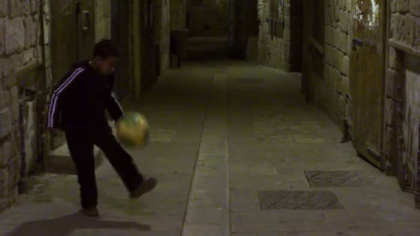 Хлопчик штовхає футбольний м'яч — стокове відео