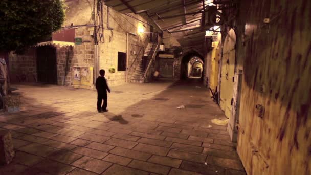 Imágenes de un niño jugando al fútbol por la noche en Israel . — Vídeo de stock